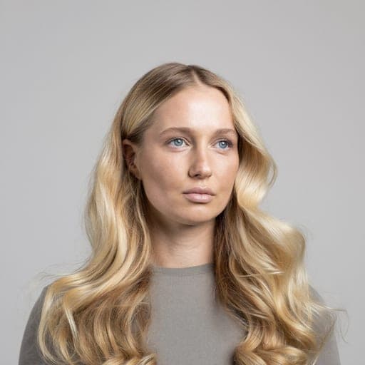 A woman with soft waves: Mid-length or long hair waved loosely, with the bend starting below the ear.