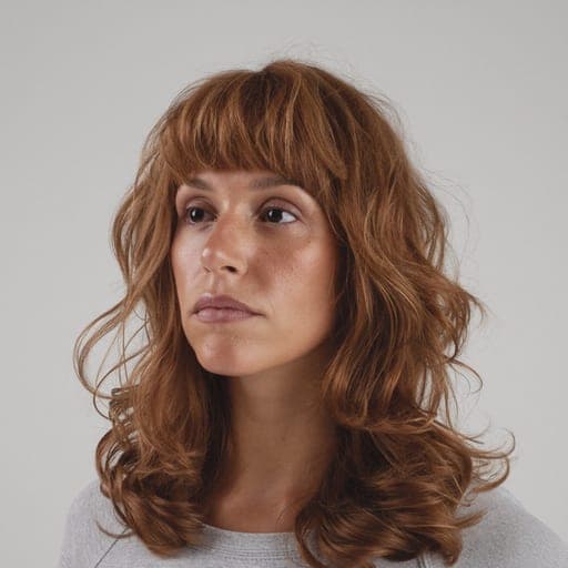 A woman with shoulder-length shag: Heavily layered and textured through the mid-lengths, usually with a fringe.